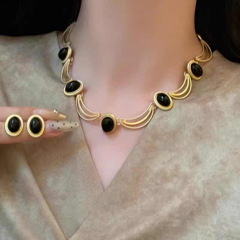 Boucles d'oreilles puces ovales cabochon noir et cadre doré texturé