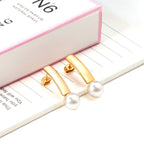 Boucles d'oreilles pendantes pour femme avec perle et finition dorée