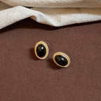 Boucles d'oreilles puces ovales cabochon noir et cadre doré texturé