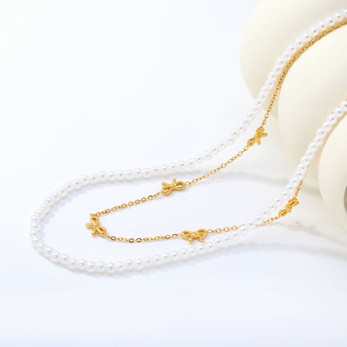 Collier multicouche pour femme avec perles délicates et pendentifs nœuds