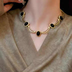 Boucles d'oreilles puces ovales cabochon noir et cadre doré texturé