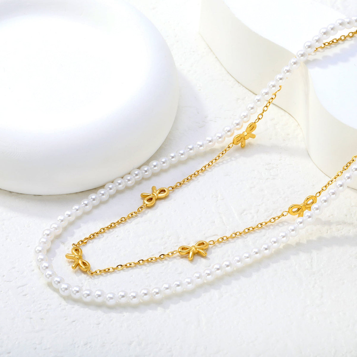 Collier multicouche pour femme avec perles délicates et pendentifs nœuds