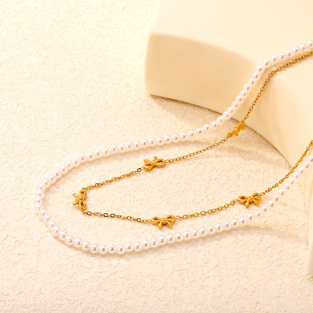 Collier multicouche pour femme avec perles délicates et pendentifs nœuds