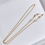 Chaîne porte-bijoux élégante avec perles et détails dorés