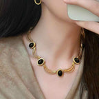 Boucles d'oreilles puces ovales cabochon noir et cadre doré texturé