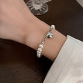 Bracelet élégant en perles argentées avec détails en forme de cœur