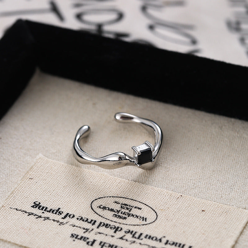 Bague ouverte pour femme au design ondulé avec pierre noire