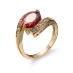 Bague dorée géométrique avec pierre rouge