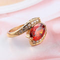 Bague dorée géométrique avec pierre rouge