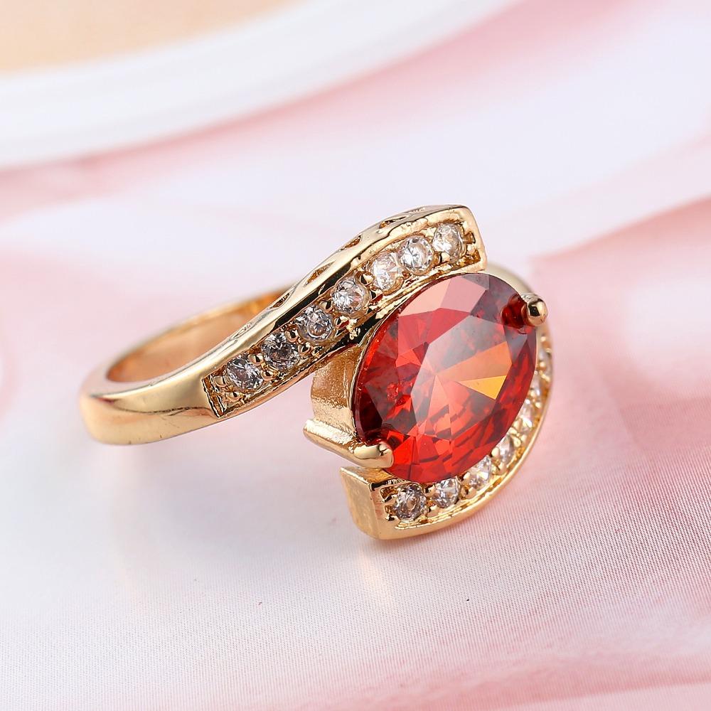 Bague dorée géométrique avec pierre rouge